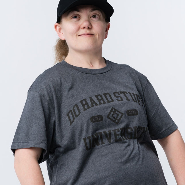 Side angle of the Do Hard Stuff Alma Mater tee with hands in pockets