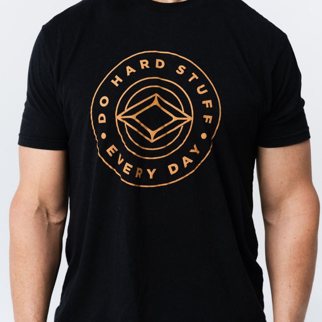Close-up of Do Hard Stuff Every Day logo on black tee