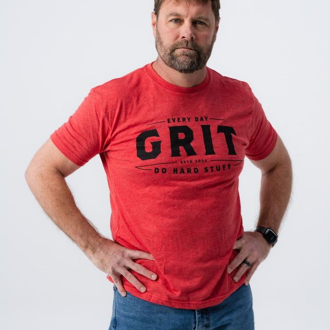 Confident man in Do Hard Stuff Grit Tee standing with hands on hips.