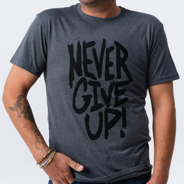 Man smiling in Do Hard Stuff Never Give Up tee viewed from side