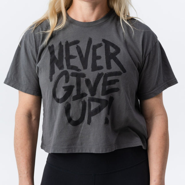 Smiling model wearing Do Hard Stuff Never Give Up charcoal crop tee