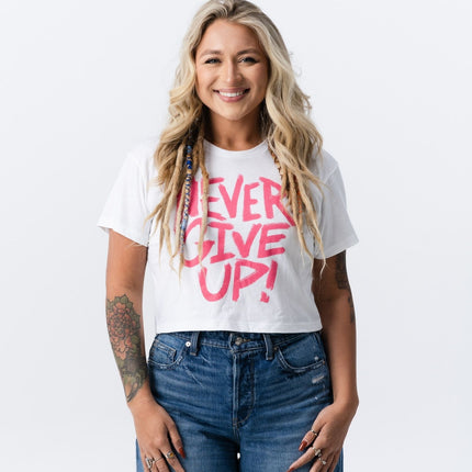 Blonde woman smiling in jeans and a pink and white Do Hard Stuff motivational crop tee.