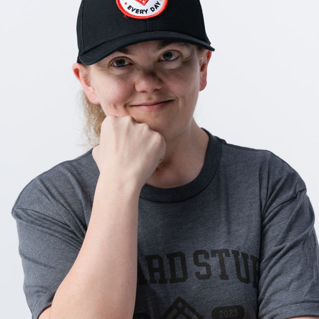Close-up of woman wearing the black Inner Circle Hat with red and white "Do Hard Stuff Every Day" patch.