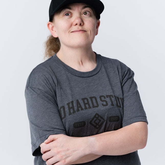 Woman standing confidently wearing the Inner Circle Hat and Do Hard Stuff tee.