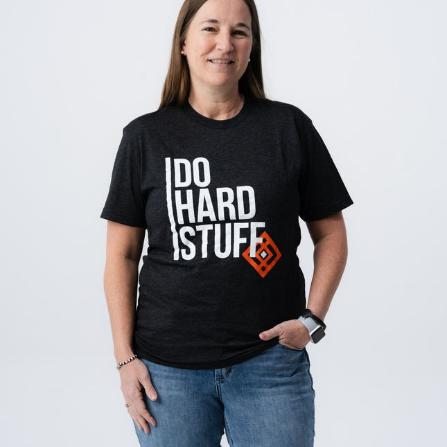 Woman wearing Do Hard Stuff Mantra Tee with hands in pockets, front view